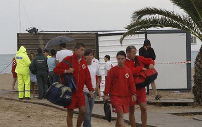 Miembros de la Guardia Civil y los sanitarios ante la caseta de la Cruz Roja que ha volcado el viento y aplastado a un hombre en Burriana