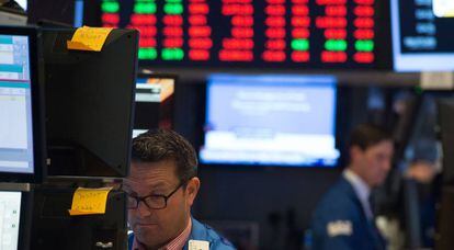 Inversores miran las pantallas de las cotizaciones de Wall Street.