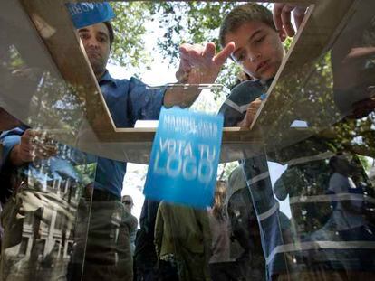 Varios ciudadanos votando ayer su logo preferido para la candidatura olímpica de Madrid.