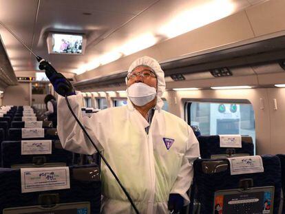 Un trabajador uniformado lleva a cabo tareas de desinfección en un tren en la ciudad de Seúl, en Corea del Sur.
