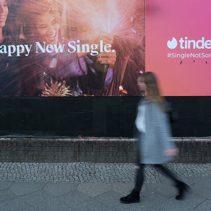 Una mujer pasa por delante de un anuncio de la aplicación de citas Tinder.