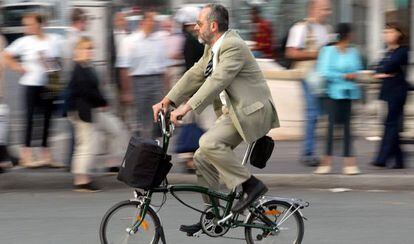 Un home passeja amb bicicleta per París.