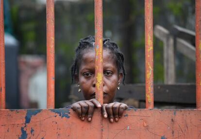 Una residente del West Point, un suburbio de Monrovia (Liberia), detr&aacute;s de una de las vallas que cierra el barrio por la cuarentena ante el &eacute;bola. 