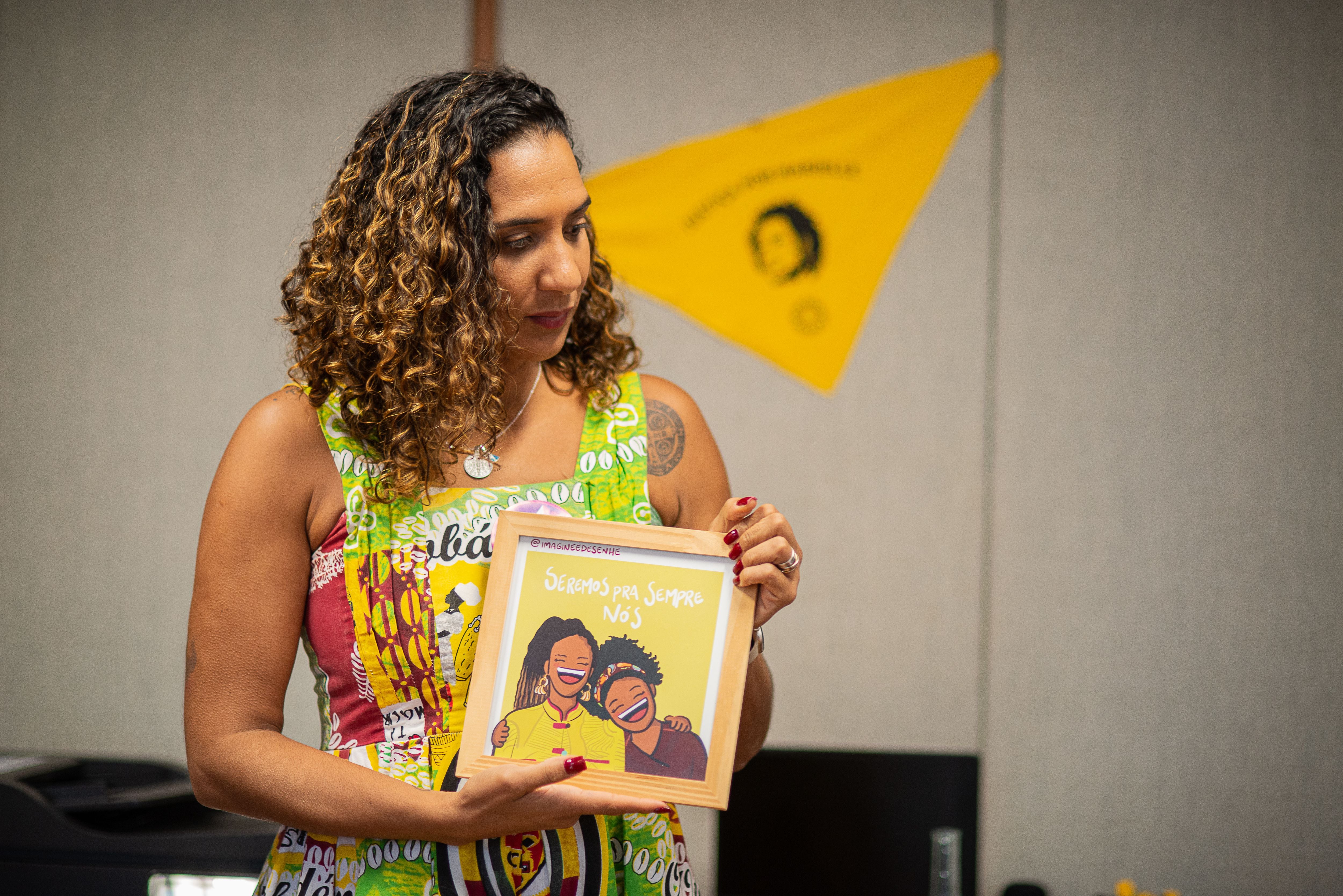 La ministra de Igualdad Racial, Anielle Franco, sostiene una imagen realizada en memoria de su hermana, Marielle, en su despacho en Brasilia.
