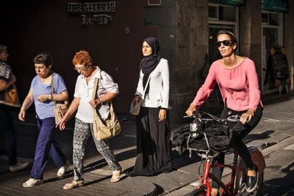 En el centro, con hiyab negro, Ramia Chaoui, fotografiada en el barrio de El Raval en Barcelona, ciudad a la que llegó siendo muy pequeña. Está casada y es de procedencia marroquí. Es licenciada en Administración y Dirección de Empresas. Trabaja en una firma farmacéutica.