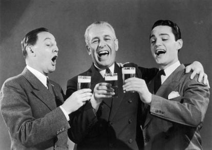 Tres amigos durante un brindis en una imagen publicitaria tomada en 1950.