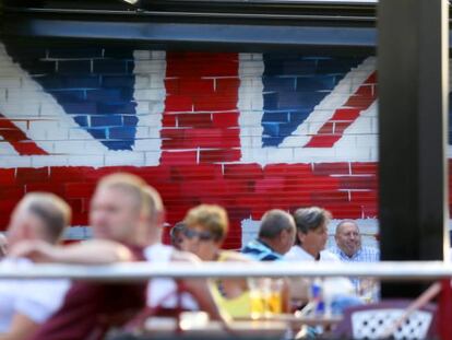 Turistas en una terraza en Benidorm, decorada con la bandera británica. 