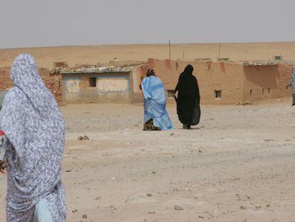 Varias mujeres caminan hacia sus casas de adobe en el campo de refugiados de los saharauis del en Tinduf (Argelia).