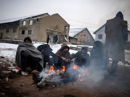 Un grupo de migrantes se calientan alrededor de una hoguera, en Belgrado. 