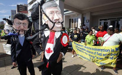 Un grupo de ecologistas se manifiestan hoy en Durban con caretas del presidente de la Comisión Europea, Durao Barroso, y el primer ministro de Canadá, Stephen Harper