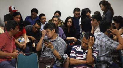 Familiares de los pasajeros del avión desaparecido esperan noticias en el aeropuerto de Surabaya.