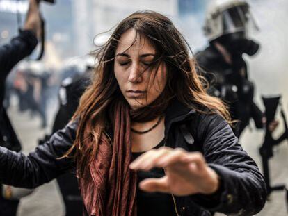 Una manifestante en Estambul escapa de los gases lacrim&oacute;genos.