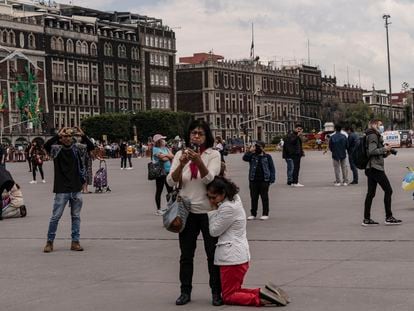 En el Zócalo, una mujer se arrodilla y recarga en otra luego del terremoto registrado el 19 de septiembre de 2022.