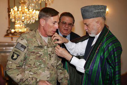 El presidente afgano, Hamid Karzai, condecora al general David Petraeus, ayer en Kabul.