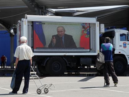 Russian President Vladimir Putin is seen on a screen broadcasting Russian TV news programs at a humanitarian aid distribution point during Ukraine-Russia conflict in the southern port city of Mariupol, Ukraine May 30, 2022. REUTERS/Alexander Ermochenko