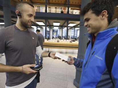 Un joven compra en Madrid uno de los modelos de Iphone 6s, el nuevo teléfono que Apple ha puesto a la venta hoy en España y México.