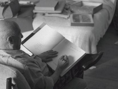 Picasso escriu una dedicatòria en un dels seus llibres en el dormitori de la seva casa de Mougins.