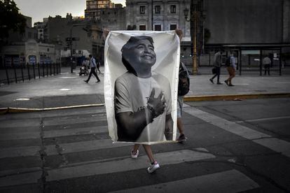 El velatorio de Diego Maradona ha terminado y la multitud abandona la Plaza de Mayo. Muchos se quedaron fuera de la Casa Rosada y no pudieron despedir al ídolo. En la foto, un hombre porta una foto del ídolo.