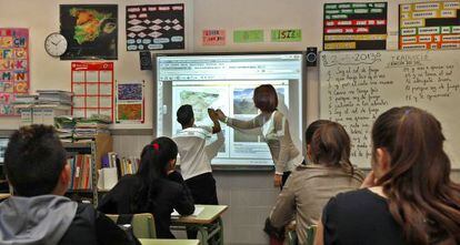 Una profesora imparte clase con una pizarra digital en el colegio público de Valencia.