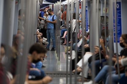 Viajeros en el interior de un vagón del metro de Madrid.