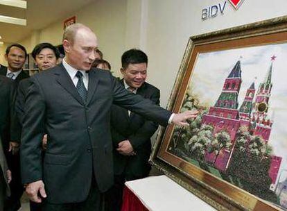 Vladímir Putin observa un cuadro del Kremlin que le regaló una entidad financiera ayer en Hanoi.
