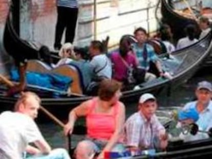 Turistas en góndolas en un canal de Venecia