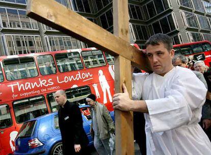 Un hombre lleva una cruz de madera encabezando una procesión en Londres, durante las celebraciones de la Semana Santa. Cientos de personas se han reunido para la procesión anual de Semana Santa donde el crucifijo es portado desde Westminster Hall a la catedral y finalmente a la Abadía.