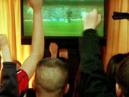 Gente viendo un partido de fútbol en un bar