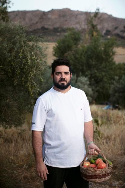 El cocinero Pedro Aguilera, del gaditano Mesón Sabor Andaluz, con una cesta de tomates recién cogidos del huerto ecológico de la asociación Extiercol, en Málaga. 