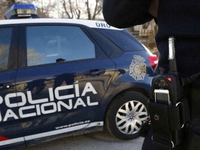 Un agente y un coche patrulla de la Policía Nacional de Valladolid.
