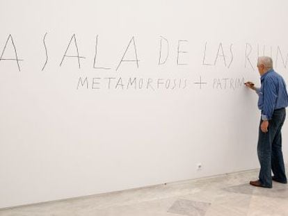 Jos&eacute; Ram&oacute;n Sierra pinta el t&iacute;tulo de una sala de su muestra en Sevilla.