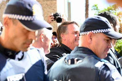 Bolsonaro, rodeado de policías, saluda a sus seguidores en Brasilia, este jueves.