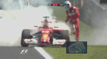 Fernando Alonso intenta apagar el fuego de su Ferrari.