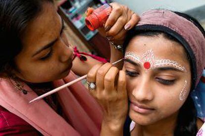 Dos adolescentes practican el arte del maquillaje tradicional de boda en una escuela de estética de Rajastán.