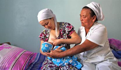 Gulonur Bekbosinova amamanta a su recién nacido de un día de edad, Arman. La madre es ayudada por una enfermera, en el hospital de Khujayli, en la región de Karakalpakstan. El centro participa en la Iniciativa de Hospitales Amigos de la Niñez (IHAN), un esfuerzo conjunto del Unicef y la Organización Mundial de la Salud (OMS) para asegurar que todas las salas de maternidad brindan apoyo para fomentar la lactancia materna.