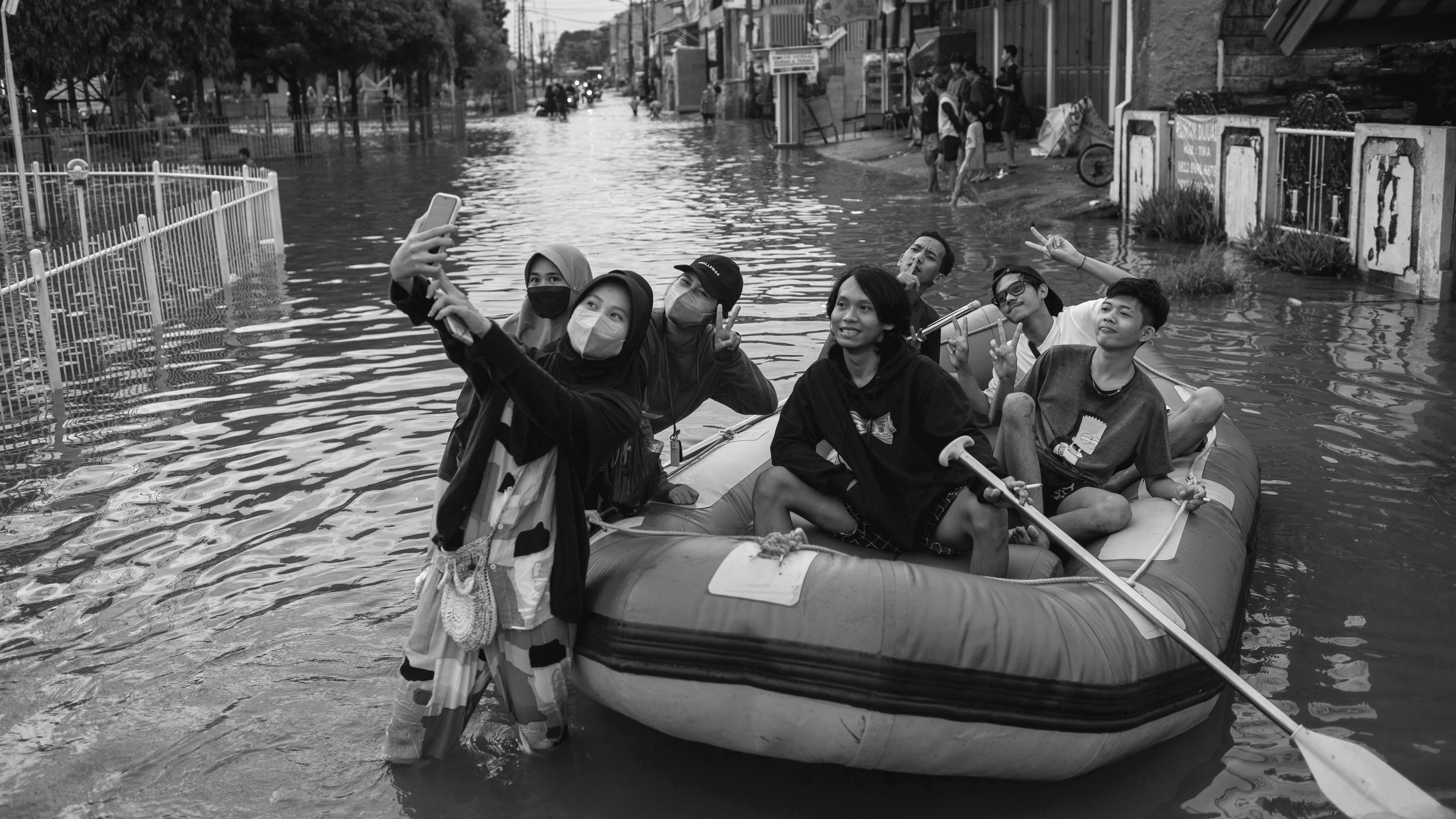Adolescentes se hacen un 'selfie' en medio de la inundación en Bekasi (Indonesia), en febrero de 2023.