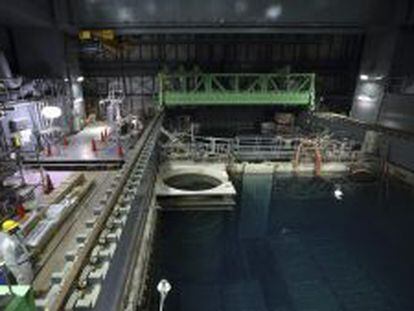 Un empleado de Tokyo Electric Power (TEPCO) se protege con un traje y una m&aacute;scara mientras trabaja en la piscina del reactor 4 en la central nuclear de Fukushima.