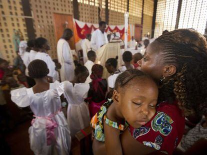Un ni&ntilde;o duerme en brazos de su madre durante la misa en una iglesia de Garissa este domingo. 