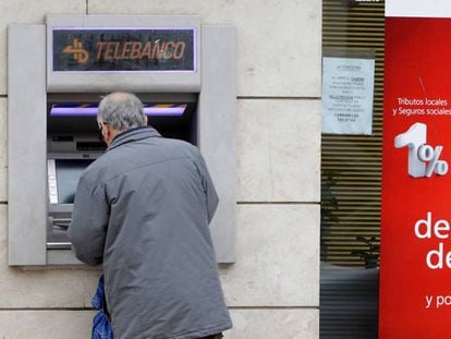 Un cliente bancario saca dinero de un cajero automático en Madrid, en una imagen de archivo.