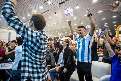 Aficionados de la selección de argentina festejan el triunfo  contra la selección australiana en uno de los pasillos de FIL.