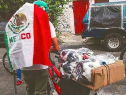 Un ciclista, con la bandera de México, arregla su carga para llevarla a los damnificados tras el sismo del pasado 19 de septiembre.