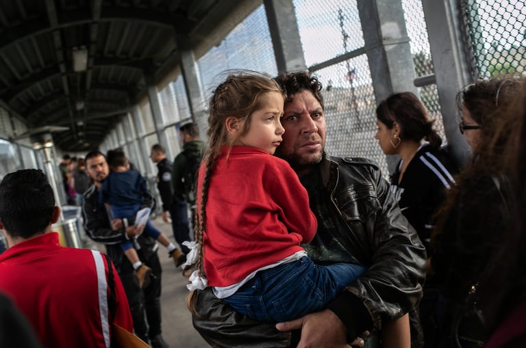 Solicitantes de asilo caminan de regreso a través del puente internacional de Estados Unidos a México después de su audiencia en la corte de inmigración en Texas.