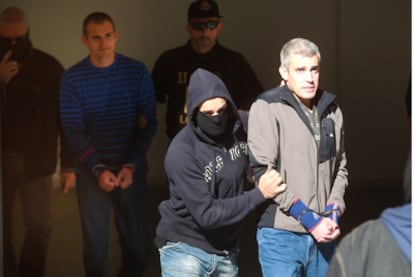Mattin Sarasola, a la derecha, e Igor Portu, detrás, ambos esposados, a la salida de la Audiencia de Guipúzcoa tras prestar declaración en San Sebastián.