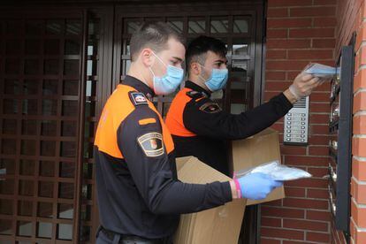 Dos voluntarios de Protección Civil, durante el reparto de mascarillas este jueves en Torrejón de Ardoz, Madrid.