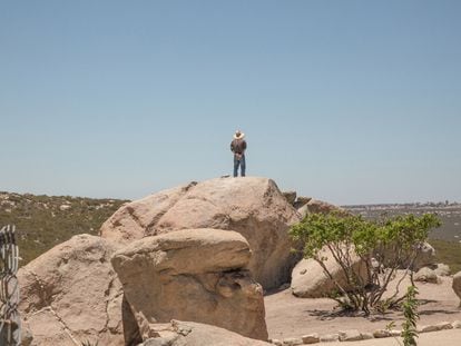 Un vigilante sobre una roca en los límites del centro rehabilitación controla que ningún interno intente escaparse. A unos pocos kilómetros puede apreciarse el muro que divide Estados Unidos de México.