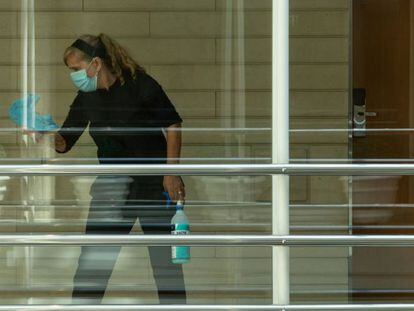Una trabajadora desinfecta una zona de paso de un hotel.