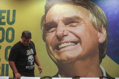 Uno de los candidatos ultraderechistas, este domingo, de espaldas al cartel con la imagen del líder Jair Bolsonaro.