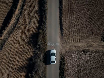 Vista aérea de la tubería de agua que va junto a una de las carreteras del municipio de Cabrera d'Anoia, que realiza cortes de agua por las noches. En el asfalto, una pintada donde se puede leer Agua 24h SOS.