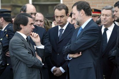 José María Aznar, entonces presidente del Gobierno, José Luis Rodríguez Zapatero, secretario general del PSOE, y Mariano Rajoy, secretario general del PP, hablan durante el funeral por el policía fallecido.