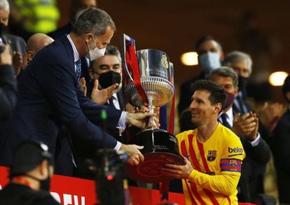 Felipe VI entrega el trofeo de la Copa del Rey a Lionel Messi, capitán del Barcelona, tras ganar la final (0-4) al Athletic de Bilbao, en el estadio de La Cartuja de Sevilla en abril de 2021.